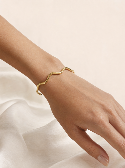 Woman wearing gold wavy cuff bracelet