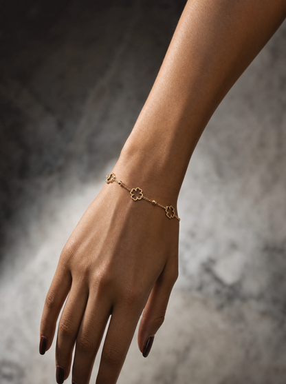 Gold four-leaf clover bracelet on wrist