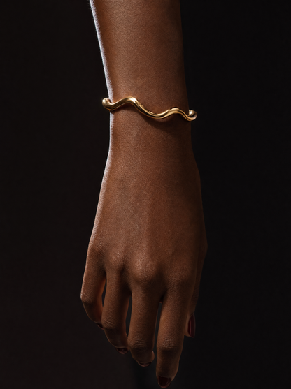Gold wave cuff bracelet on wrist