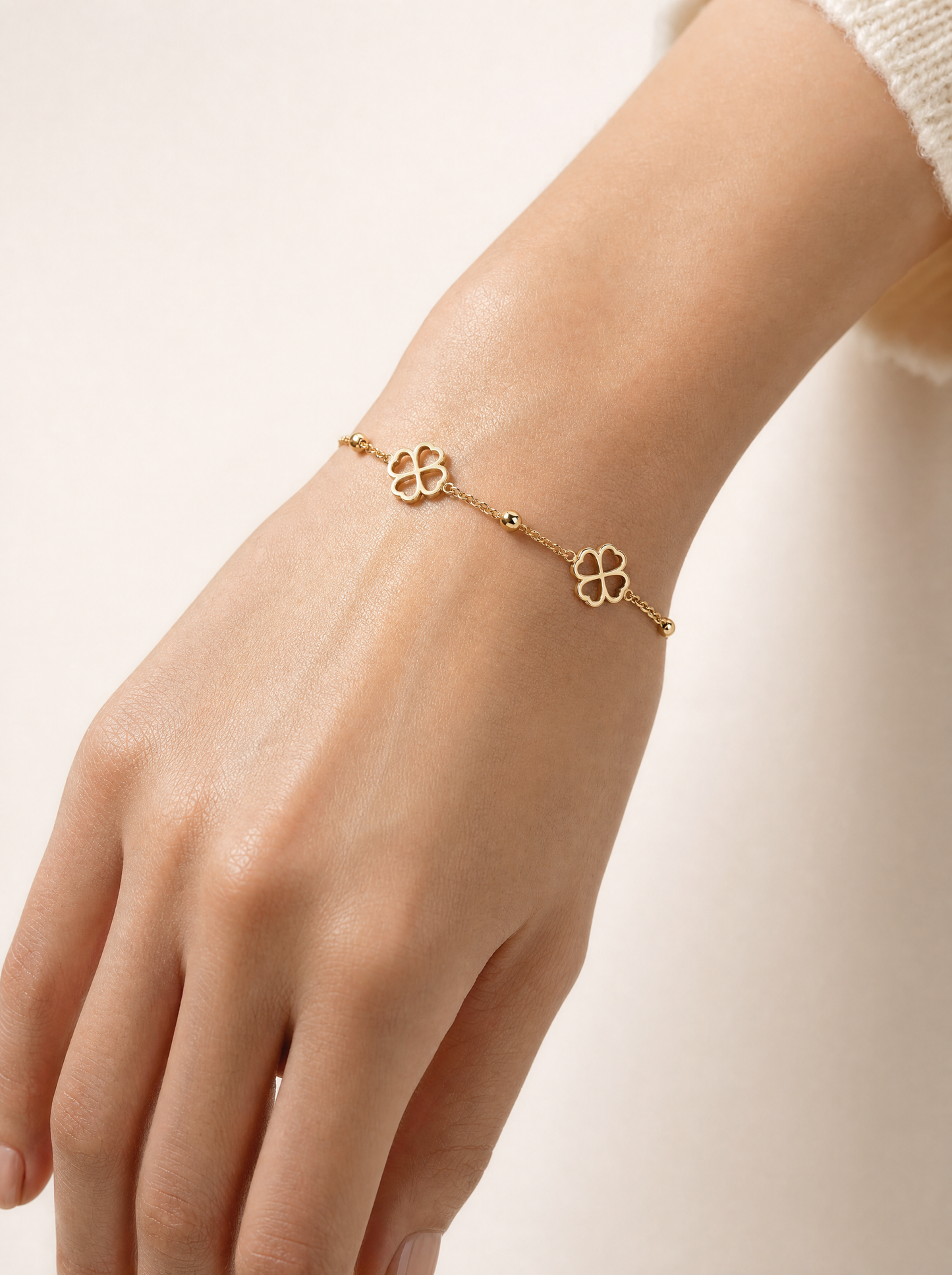 Woman wearing gold four-leaf clover chain bracelet