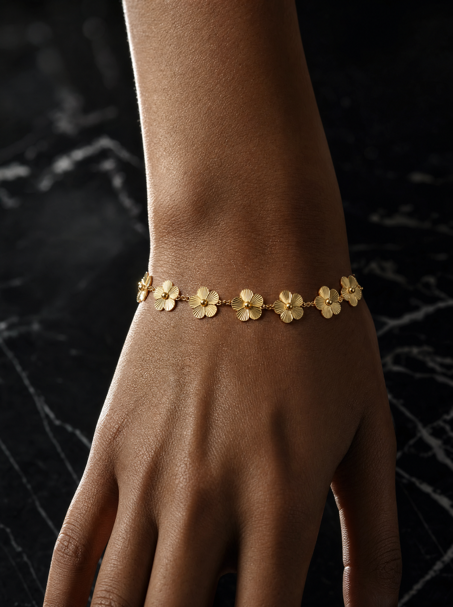 Gold flower station bracelet on wrist