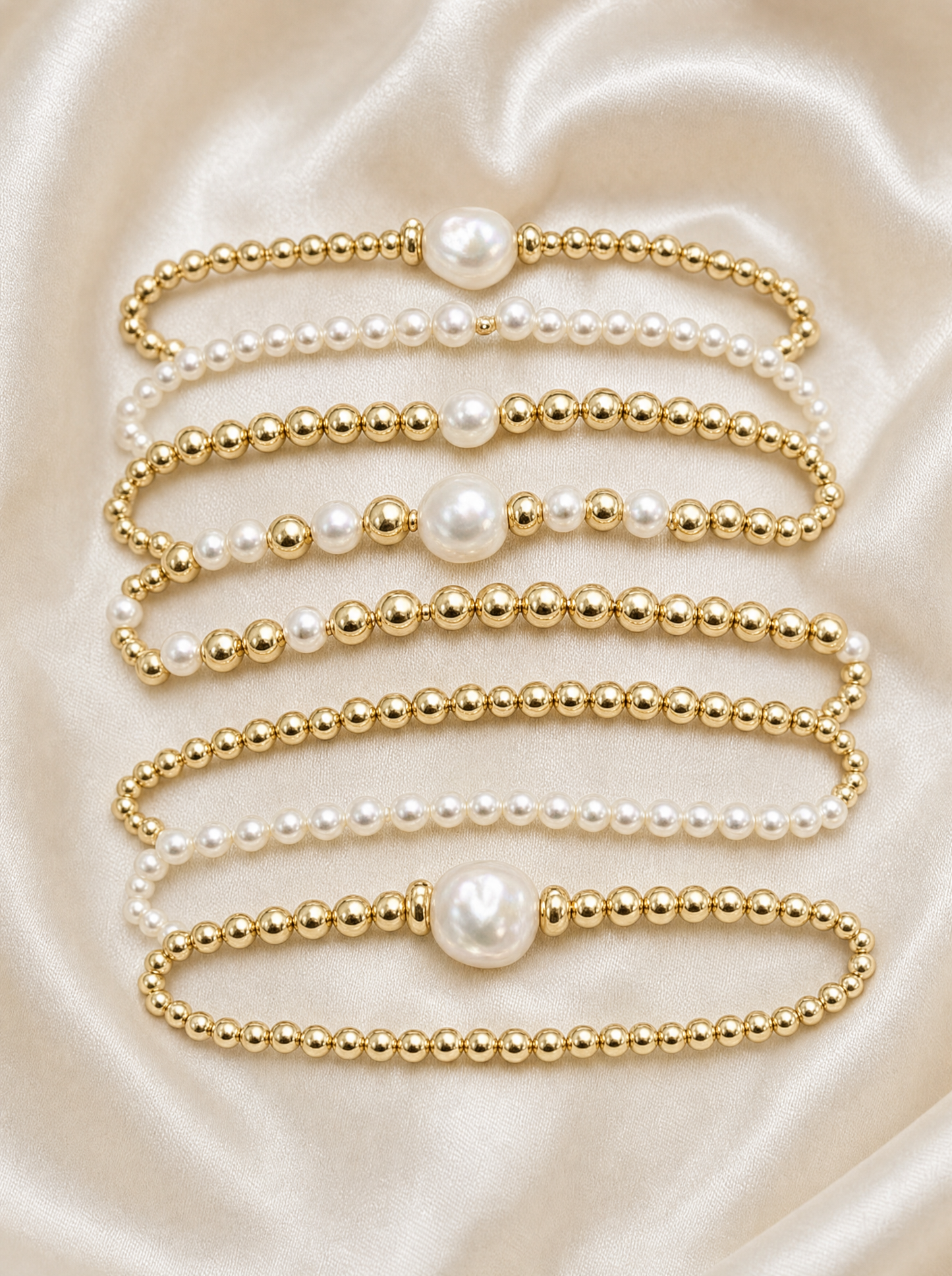 Pearl and gold bead stackable bracelet set, flat lay of all 7 pieces