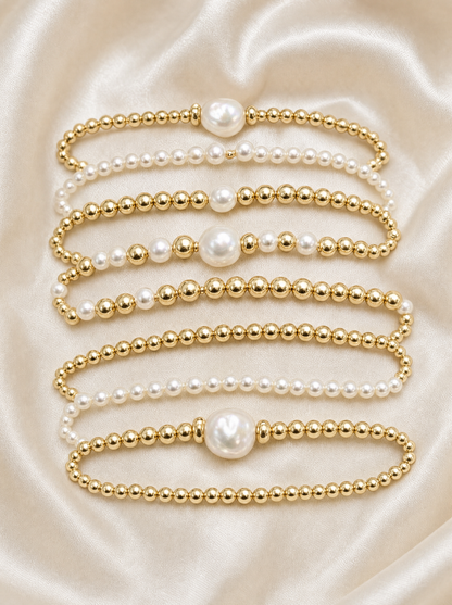 Pearl and gold bead stackable bracelet set, flat lay of all 7 pieces
